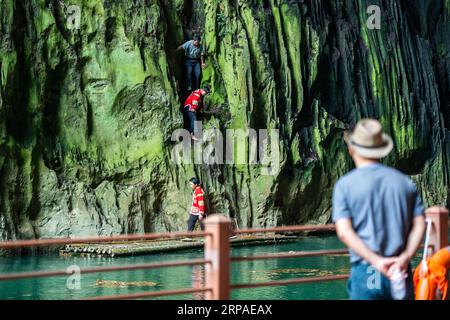 (190506) -- ZIYUN, 6. Mai 2019 (Xinhua) -- Foto aufgenommen am 19. April 2019 zeigt einen Touristen, der die Klippenspinnen im malerischen Gebiet des Getu River im Miao-Bouyei Autonomous County Ziyun, Anshun, im Südwesten der chinesischen Provinz Guizhou, kostenlos im Alleingang beobachtet. Luo Dengping aus der Miao-Ethnie, 38, konnte in 20 Minuten auf einer 80 Meter hohen Klippe ohne Hilfsmittel und ohne Schutz in der malerischen Gegend des Getu River ein freies hin- und herklettern. Fünf weitere Klippenspinnen wie Luo spielen zweimal bis fünf Mal am Tag ein kostenloses Solo für die Touristen. (Xinhua/Tao Liang) CHINA-GUIZHOU-ANSHUN-FREIER AUFSTIEG Stockfoto