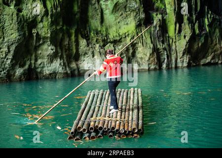 (190506) -- ZIYUN, 6. Mai 2019 (Xinhua) -- Foto aufgenommen am 19. April 2019 zeigt die Klippenspinnenfrau Luo Dengping, die zu einer Klippe am Getu River rudert. Luo Dengping aus der Miao-Ethnie, 38, konnte in 20 Minuten auf einer 80 Meter hohen Klippe ohne Hilfsmittel und ohne Schutz in der malerischen Gegend des Getu River ein freies hin- und herklettern. Fünf weitere Klippenspinnen wie Luo spielen zweimal bis fünf Mal am Tag ein kostenloses Solo für die Touristen. (Xinhua/Tao Liang) CHINA-GUIZHOU-ANSHUN-FREE CLIMBING-SPIDERM Stockfoto