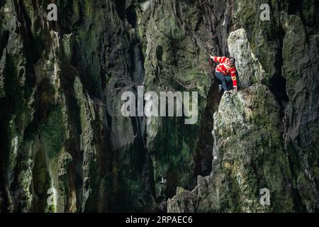 (190506) -- ZIYUN, 6. Mai 2019 (Xinhua) -- Foto aufgenommen am 19. April 2019 zeigt die Klippenspinnenfrau Luo Dengping, die eine steile Klippe am Getu River hinunterkriecht. Luo Dengping aus der Miao-Ethnie, 38, konnte in 20 Minuten auf einer 80 Meter hohen Klippe ohne Hilfsmittel und ohne Schutz in der malerischen Gegend des Getu River ein freies hin- und herklettern. Fünf weitere Klippenspinnen wie Luo spielen zweimal bis fünf Mal am Tag ein kostenloses Solo für die Touristen. (Xinhua/Tao Liang) CHINA-GUIZHOU-ANSHUN-FREIER AUFSTIEG Stockfoto