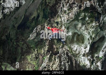 (190506) -- ZIYUN, 6. Mai 2019 (Xinhua) -- Foto aufgenommen am 19. April 2019 zeigt die Klippenspinnenfrau Luo Dengping, die eine steile Klippe am Getu River hoch kriecht. Luo Dengping aus der Miao-Ethnie, 38, konnte in 20 Minuten auf einer 80 Meter hohen Klippe ohne Hilfsmittel und ohne Schutz in der malerischen Gegend des Getu River ein freies hin- und herklettern. Fünf weitere Klippenspinnen wie Luo spielen zweimal bis fünf Mal am Tag ein kostenloses Solo für die Touristen. (Xinhua/Tao Liang) CHINA-GUIZHOU-ANSHUN-FREIES KLETTERN- Stockfoto