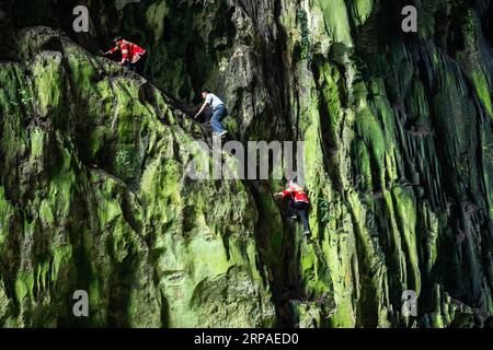 (190506) -- ZIYUN, 6. Mai 2019 (Xinhua) -- Foto aufgenommen am 19. April 2019 zeigt die Klippenspinnen, die im malerischen Getu River im Miao-Bouyei Autonomous County Ziyun, Anshun, Provinz Guizhou im Südwesten Chinas, kostenlos solo auftreten. Luo Dengping aus der Miao-Ethnie, 38, konnte in 20 Minuten auf einer 80 Meter hohen Klippe ohne Hilfsmittel und ohne Schutz in der malerischen Gegend des Getu River ein freies hin- und herklettern. Fünf weitere Klippenspinnen wie Luo spielen zweimal bis fünf Mal am Tag ein kostenloses Solo für die Touristen. (Xinhua/Tao Liang) CHINA-GUIZHOU-ANSHUN-FREE CLIMBING- SPIDERMEN (CN) Stockfoto