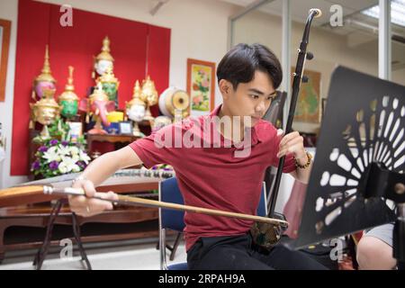 (190511) -- BANGKOK, 11. Mai 2019 (Xinhua) -- Pakkawat spielt die Erhu mit seinen Freunden der Tianxian Band in einem Klassenzimmer in der Huachiew Chalermprakiet Universität in Bangkok, Thailand, 10. März 2019. Die Thai-Band Tianxian, wörtlich himmlische Streicher, besteht aus mehreren Thais, die verrückt nach chinesischen Musikinstrumenten sind. Seltsam genug, aber keiner von ihnen kann fließend Chinesisch sprechen. In der thailändischen Gesellschaft, in der westliche Musikinstrumente dominieren, ist eine Band mit chinesischen Musikinstrumenten nichts anderes als eine Seltenheit. Sanchai, eines der Bandmitglieder, ist Musiklehrer am HUAC Stockfoto