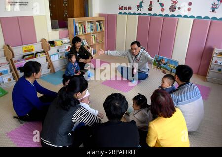 (190512) -- NINGSHAN, 12. Mai 2019 (Xinhua) -- die Lehrerin Yue Youlin erzählt am 11. Mai 2019 in Chengnan Baby Center der Gemeinde Chengguan im Ningshan County, Provinz Shaanxi im Nordwesten Chinas, Geschichten mit einem Bilderbuch für Säuglinge. Ningshan liegt tief im Herzen der Qinling Mountains und ist ein vom Staat unterstütztes verarmtes County. Ein experimentelles Projekt, das Kindern unter drei Jahren eine kostenlose Früherziehung und eine kostenlose Erziehungsausbildung bietet, wird hier durchgeführt. Sie soll Kindern, die in verarmten Gebieten leben, helfen, besser aufzuwachsen. Mehr als 1.000 Kinder in Ningshan haben davon profitiert Stockfoto