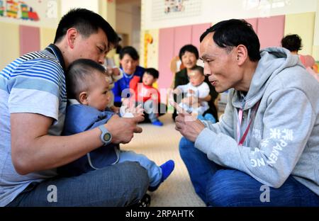 (190512) -- NINGSHAN, 12. Mai 2019 (Xinhua) -- Lehrerin Yue Youlin (R) interagiert am 11. Mai 2019 mit einem Säugling in Chengnan Baby Center der Gemeinde Chengguan im Ningshan County, Provinz Shaanxi im Nordwesten Chinas. Ningshan liegt tief im Herzen der Qinling Mountains und ist ein vom Staat unterstütztes verarmtes County. Ein experimentelles Projekt, das Kindern unter drei Jahren eine kostenlose Früherziehung und eine kostenlose Erziehungsausbildung bietet, wird hier durchgeführt. Sie soll Kindern, die in verarmten Gebieten leben, helfen, besser aufzuwachsen. Mehr als 1.000 Kinder in Ningshan haben von diesem Projekt profitiert. Xi Stockfoto