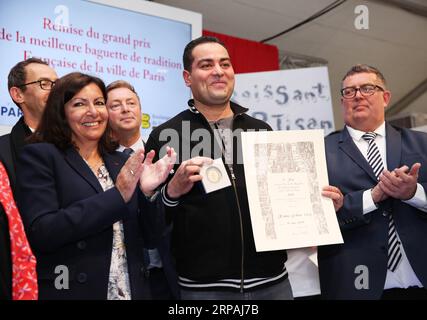 (190512) -- PARIS, 12. Mai 2019 (Xinhua) -- Fabrice Leroy (Front C) erhält den Großen Preis des besten traditionellen Pariser Baguettes von der Pariser Bürgermeisterin Anne Hidalgo (Front L) während der Preisverleihung in Paris, Frankreich, 11. Mai 2019. Das 24. Brotfestival findet vom 11. Bis 19. Mai in Paris am Place Louis L¨¦Pine statt, nur einen Steinwurf von Notre Dame entfernt. (Xinhua/Gao Jing) FRANCE-PARIS-BREAD FESTIVAL PUBLICATIONxNOTxINxCHN Stockfoto