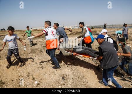 (190515) -- GAZA, 15. Mai 2019 -- palästinensische Sanitäter tragen einen Verwundeten bei Zusammenstößen mit israelischen Truppen an der Grenze zwischen Gaza und Israel, östlich des Gazastreifens, 15. Mai 2019. Mindestens 47 Palästinenser wurden am Mittwoch bei ihren Zusammenstößen mit israelischen Soldaten verletzt, während sie den 71. Jahrestag des Nakba-Tages oder des Tages der Katastrophe, den Tag nach der Unabhängigkeitserklärung Israels im Jahr 1948, begehen. Stringer) MIDEAST-GAZA-KONFLIKTE ZhaoxYue PUBLICATIONxNOTxINxCHN Stockfoto