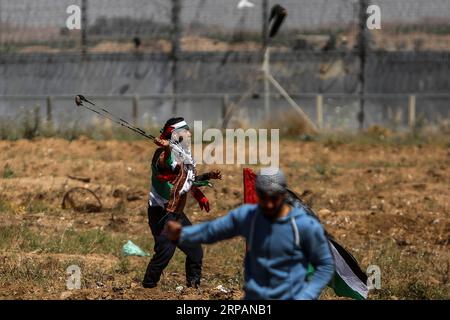 (190515) -- GAZA, 15. Mai 2019 -- Ein palästinensischer Demonstrant verwendet eine Schleuder, um Steine auf israelische Truppen während der Zusammenstöße an der Grenze zwischen Gaza und Israel, östlich des Gazastreifens, am 15. Mai 2019 zu schleudern. Mindestens 47 Palästinenser wurden am Mittwoch bei ihren Zusammenstößen mit israelischen Soldaten verletzt, während sie den 71. Jahrestag des Nakba-Tages oder des Tages der Katastrophe, den Tag nach der Unabhängigkeitserklärung Israels im Jahr 1948, begehen. ) MIDEAST-GAZA-CLASHES Stringer PUBLICATIONxNOTxINxCHN Stockfoto