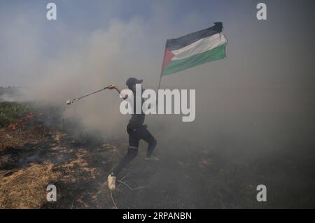 (190515) -- GAZA, 15. Mai 2019 -- Ein palästinensischer Demonstrant schleudert mit einer Schleuder Steine auf israelische Truppen während der Auseinandersetzungen an der Grenze zwischen Gaza und Israel, östlich der Stadt Khan Younis im südlichen Gazastreifen, 15. Mai 2019. Mindestens 65 Palästinenser wurden am Mittwoch bei Zusammenstößen mit israelischen Soldaten verletzt, die an der Grenze zwischen dem östlichen Gazastreifen und Israel stationiert waren, sagten Mediziner. MIDEAST-GAZA-KONFLIKTE KhaledxOmar PUBLICATIONxNOTxINxCHN Stockfoto