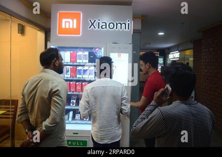 (190518) -- BANGALORE, 18. Mai 2019 -- die Leute benutzen den ersten Mi Express Kiosk, einen Automaten des chinesischen Xiaomi, in Bangalore, Indien, 17. Mai 2019. Xiaomi, ein chinesisches Elektronikunternehmen mit Hauptsitz in Peking, kündigte eine neue innovative Mi Express Kiosk-Initiative in Bangalore, Indien, an. In einer Veröffentlichung der Ankündigung heißt es, dass die neuen Mi Express-Kioske Verkaufsautomaten sind, mit denen Verbraucher und Mi-Fans Xiaomi Smartphones und mobiles Zubehör direkt erwerben können. Die Kioske sind so konzipiert, dass sie alle Arten von Zahlungen mit Kreditkarten, Debitkarten, Bargeld und UPI akzeptieren können, was sie zu einem hochgradig konventionellen Zahlungsmittel macht Stockfoto