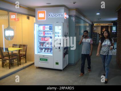 (190518) -- BANGALORE, 18. Mai 2019 -- Menschen laufen am ersten Mi Express Kiosk vorbei, einem Automaten des chinesischen Xiaomi, in Bangalore, Indien, 17. Mai 2019. Xiaomi, ein chinesisches Elektronikunternehmen mit Hauptsitz in Peking, kündigte eine neue innovative Mi Express Kiosk-Initiative in Bangalore, Indien, an. In einer Veröffentlichung der Ankündigung heißt es, dass die neuen Mi Express-Kioske Verkaufsautomaten sind, mit denen Verbraucher und Mi-Fans Xiaomi Smartphones und mobiles Zubehör direkt erwerben können. Die Kioske sind so konzipiert, dass sie alle Arten von Zahlungen mit Kreditkarten, Debitkarten, Bargeld und UPI akzeptieren können, was sie zu einem äußerst C macht Stockfoto