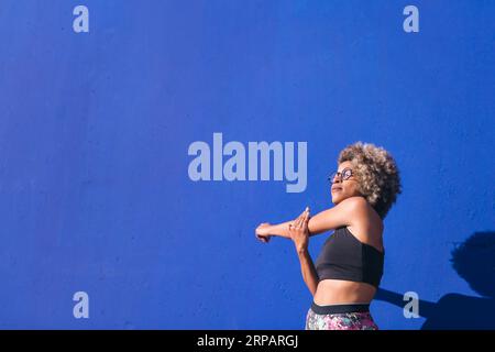 afroamerikanische Sportlerin, die Arme streckt Stockfoto