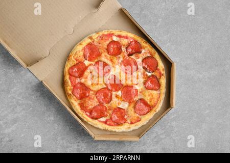 Blick von oben auf die klassische Peperoni-Pizza in einer Pappschachtel Stockfoto