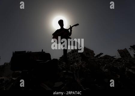 (190518) -- GAZA, 18. Mai 2019 -- Ein palästinensischer Künstler spielt auf den Trümmern eines Gebäudes, das kürzlich durch israelische Luftangriffe zerstört wurde, in Gaza-Stadt, 18. Mai 2019. Auf den Ruinen eines Wohngebäudes im Gazastreifen, das von israelischen Kriegsjets zerstört wurde, schickte eine Gruppe palästinensischer Sänger am Samstag eine anti-israelische Botschaft an den Eurovision Song Contest in Israel. Yasser Qudih) MIDEAST-GAZA-MUSIK-ANTI-ISRAEL-BOTSCHAFT zhaoyue PUBLICATIONxNOTxINxCHN Stockfoto