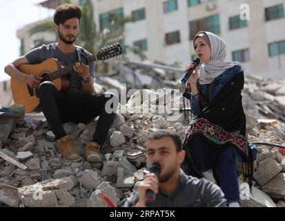 (190518) -- GAZA, 18. Mai 2019 -- palästinensische Künstler treten auf den Trümmern eines Gebäudes auf, das kürzlich durch israelische Luftangriffe zerstört wurde, in Gaza-Stadt, 18. Mai 2019. Auf den Ruinen eines Wohngebäudes im Gazastreifen, das von israelischen Kriegsjets zerstört wurde, schickte eine Gruppe palästinensischer Sänger am Samstag eine anti-israelische Botschaft an den Eurovision Song Contest in Israel. Yasser Qudih) MIDEAST-GAZA-MUSIK-ANTI-ISRAEL-BOTSCHAFT zhaoyue PUBLICATIONxNOTxINxCHN Stockfoto