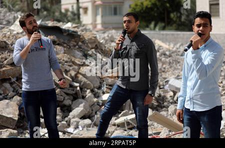 (190518) -- GAZA, 18. Mai 2019 -- palästinensische Künstler singen auf den Trümmern eines Gebäudes, das kürzlich durch israelische Luftangriffe zerstört wurde, in Gaza-Stadt, 18. Mai 2019. Auf den Ruinen eines Wohngebäudes im Gazastreifen, das von israelischen Kriegsjets zerstört wurde, schickte eine Gruppe palästinensischer Sänger am Samstag eine anti-israelische Botschaft an den Eurovision Song Contest in Israel. Yasser Qudih) MIDEAST-GAZA-MUSIK-ANTI-ISRAEL-BOTSCHAFT zhaoyue PUBLICATIONxNOTxINxCHN Stockfoto