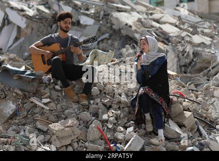 (190518) -- GAZA, 18. Mai 2019 -- palästinensische Künstler treten auf den Trümmern eines Gebäudes auf, das kürzlich durch israelische Luftangriffe zerstört wurde, in Gaza-Stadt, 18. Mai 2019. Auf den Ruinen eines Wohngebäudes im Gazastreifen, das von israelischen Kriegsjets zerstört wurde, schickte eine Gruppe palästinensischer Sänger am Samstag eine anti-israelische Botschaft an den Eurovision Song Contest in Israel. Yasser Qudih) MIDEAST-GAZA-MUSIK-ANTI-ISRAEL-BOTSCHAFT zhaoyue PUBLICATIONxNOTxINxCHN Stockfoto