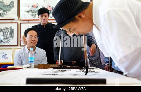 (190519) -- NANCHANG, 19. Mai 2019 (Xinhua) -- Cai Mujiang verwendet seinen Mund, um Kalligraphie bei einer behinderten Kalligraphenvereinigung in Nanchang, Hauptstadt der ostchinesischen Provinz Jiangxi, zu schreiben, 16. Mai 2019. Der 35-jährige Cai Mujiang ist ein Kalligraf mit einem Unterschied. Im Alter von 23 Jahren verlor Cai seine Arme bei einem Unfall. Trotz der Tragödie weigerte sich Cai aufzugeben und konnte sich nach mühsamen Anstrengungen um sich selbst kümmern. 2010 begann Cai, seinen Mund zu benutzen, um chinesische Kalligraphie zu schreiben. Nach einem Jahr Lernzeit beherrschte er die Fähigkeiten und verdiente sich seinen Lebensunterhalt durch das Schreiben von Kalligrafen Stockfoto