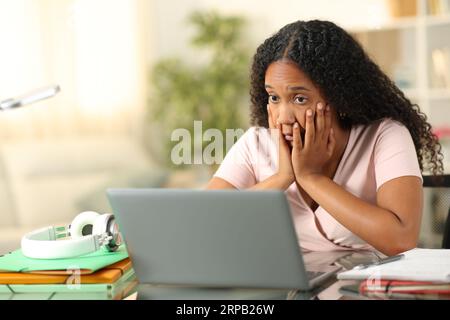 Verwirrtes E-Learning für schwarze Schüler mit einem Laptop zu Hause Stockfoto