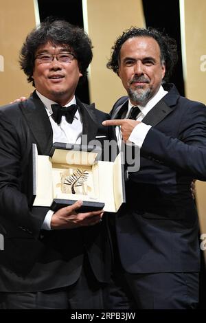 (190527) -- PEKING, 27. Mai 2019 -- Regisseur Bong Joon-Ho (L) erhält den Palme d or Award für Parasiten vom Jurypräsidenten Alejandro Gonzalez Inarritu während der Abschlusszeremonie des 72. Filmfestspiels von Cannes am 25. Mai 2019 in Cannes. Die 72. Auflage des Cannes Film Festivals fiel am Samstagabend, und der südkoreanische Filmparasit gewann den diesjährigen prestigeträchtigsten Preis, die Palme d Or. ) XINHUA FOTOS DES TAGES KimxYida PUBLICATIONxNOTxINxCHN Stockfoto