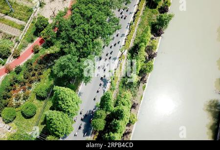 (190527) -- SHANGHAI, 27. Mai 2019 (Xinhua) -- Luftaufnahme, aufgenommen am 9. Mai 2019, zeigt Radfahrer, die im Chongming District, dem ostchinesischen Shanghai, fahren. Shanghai liegt in der Mitte der Ostküste Chinas und der Mündung des Yangtze-Flusses und ist Chinas größtes Wirtschaftszentrum sowie das regionale Drehkreuz der Yangtze-Delta-Region. Als Hinterhof dieser wohlhabenden Metropole ist Chongming Island, eines der ländlichen Bezirke Shanghais, auf dem Weg, sein Ziel zu erreichen, eine ökologische Insel von Weltklasse zu entwickeln. Die Feuchtgebiete der Insel sind erhalten, und die traditionellen Dörfer wurden renoviert. Stockfoto