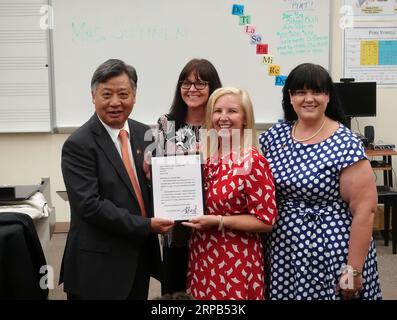 (190528) - West Palm Beach, 28. Mai 2019 (Xinhua) - Li Qiangmin, Chinesische Generalkonsul in Houston (1. L) liefert den Brief von Peng Liyuan, Frau des chinesischen Staatspräsidenten Xi Jinping, zu den Fakultäten der Bak mittlere Schule der Künste in West Palm Beach, Florida, USA, 26. April 2019. Am 7. April 2017, Peng Liyuan, Frau des chinesischen Staatspräsidenten Xi Jinping besuchte die Schule auf Einladung der First Lady der USA Melania Trump, wo Sie beobachteten die Teilnehmer führen und mit ihnen redete, Beginn der Bemühungen, eine Brücke von Menschen zu bauen - Austausch zwischen China und der Schule. Stockfoto