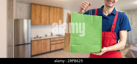 Ein junger gutaussehender Mann mit einer Liefertüte Stockfoto