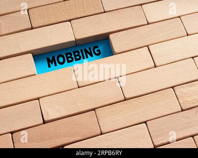 Um das verborgene Mobbing-Konzept zu enthüllen. Das Wort Mobbing, umgeben von Holzblöcken. Stockfoto