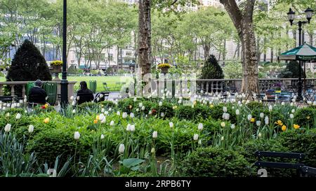 New York, New York, USA - 26. April 2023: Zwei Personen sitzen in einem ruhigen Park in New York City. Stockfoto