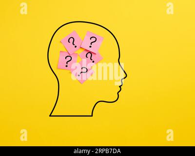 Konfusion, Abfrage und Unsicherheit. Haftnotizen in einem menschlichen Kopf mit Fragezeichen-Symbolen. Stockfoto