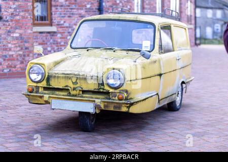 Ein klassischer historischer Reliant Robin 3-Rad-Van in der Farbe Gelb, der für die Fernsehsendung Only Fools and Horses aus den 1980er Jahren verwendet wurde Stockfoto