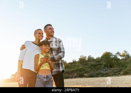 Glückliche Familie, die bei Sonnenuntergang eine Freizeitaktivität auf dem Land genießt. Stockfoto