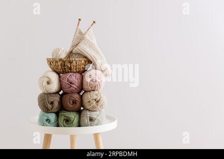 Naturwolle in Kugeln verschiedener Pastellfarben auf dem Tisch. Leerzeichen kopieren. Stockfoto