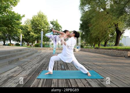 Luannan County, China - 21. Juni 2019: Eine Dame und ein kleines Mädchen, die zusammen Yoga praktizieren, Luannan County, Provinz Hebei, China. In den letzten Jahren Yoga Stockfoto