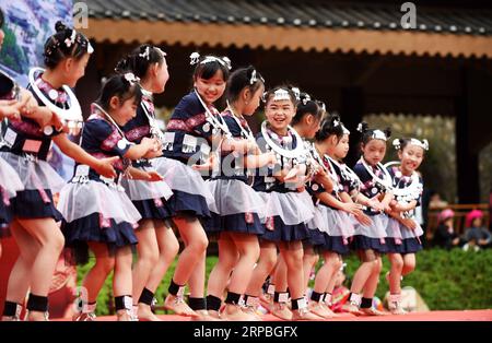 (190608) -- GUIYANG, 8. Juni 2019 (Xinhua) -- Kinder treten in der Stadt A-mei Qituo im Qinglong County, Provinz Guizhou im Südwesten Chinas, am 6. Juni 2019 auf. Die verarmten Dorfbewohner von Sanbao verlassen ihre schäbigen Häuser am steilen Hang und genießen ein besseres Leben. Die von Armut betroffenen Familien in der Stadt Sanbao sind mit Hilfe der lokalen Regierung in neue Häuser in der Stadt A-mei Qituo gezogen. (Xinhua/Yang Wenbin) CHINA-GUIZHOU-YI ETHNISCHE GRUPPE-STADT-UMSIEDLUNG-A-MEI QITUO (CN) PUBLICATIONxNOTxINxCHN Stockfoto