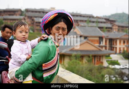 (190608) -- GUIYANG, 8. Juni 2019 (Xinhua) -- Dorfbewohner aus Sanbao sehen sich die Aufführung in der Stadt A-mei Qituo im Qinglong County, Provinz Guizhou im Südwesten Chinas, 6. Juni 2019 an. Die verarmten Dorfbewohner von Sanbao verlassen ihre schäbigen Häuser am steilen Hang und genießen ein besseres Leben. Die von Armut betroffenen Familien in der Stadt Sanbao sind mit Hilfe der lokalen Regierung in neue Häuser in der Stadt A-mei Qituo gezogen. (Xinhua/Yang Wenbin) CHINA-GUIZHOU-YI ETHNISCHE GRUPPE-STADT-UMSIEDLUNG-A-MEI QITUO (CN) PUBLICATIONxNOTxINxCHN Stockfoto