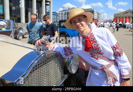 (190608) -- MINSK, 8. Juni 2019 -- Ein junger Mann in traditioneller Tracht posiert für Fotos mit einem Oldtimer während der Oldtimer-Rallye Minsk 2019 in Minsk, Belarus, am 8. Juni 2019. Oldtimer Rally Minsk 2019, ein jährlicher Wettbewerb für Oldtimer-Amateure, fand hier am Samstag statt, mit mehr als 50 Oldtimern, die vor 40 Jahren und früher hergestellt wurden. ) WEISSRUSSLAND-MINSK-OLDTIMER EfimxMazurevich PUBLICATIONxNOTxINxCHN Stockfoto