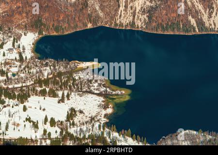 Blick aus der Vogelperspektive auf Ukanc, kleine Siedlung an der Westküste des Bohinjer Sees im Winter im slowenischen Nationalpark Triglav, berühmtes Reiseziel Stockfoto