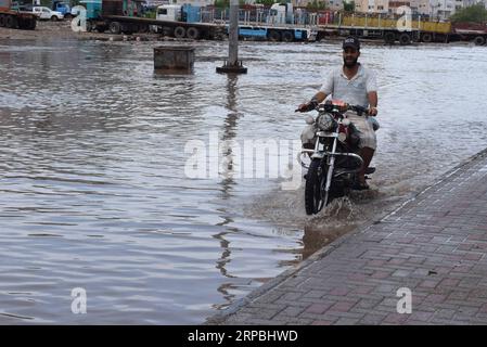 (190609) -- ADEN (JEMEN), 9. Juni 2019 -- Ein Motorradfahrer waten am 9. Juni 2019 durch Wasser in der südlichen Hafenstadt Aden, Jemen. Mindestens drei Menschen starben im Jemen nach schweren Regenfällen und Überschwemmungen, die am Sonntag mehrere Teile der südlichen und östlichen Provinzen des Landes heimsuchten. JEMEN-ADEN-SCHWERER REGEN MuradxAbdo PUBLICATIONxNOTxINxCHN Stockfoto