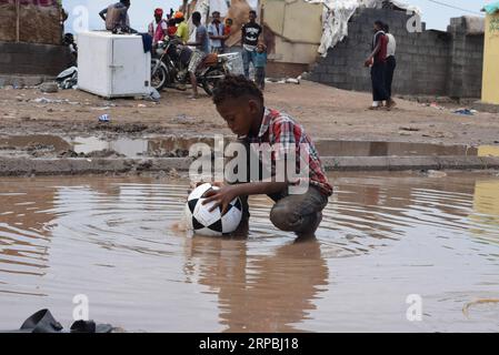 (190609) -- ADEN (JEMEN), 9. Juni 2019 -- Ein Kind wäscht seinen Ball in der Nähe seines Verdrängungslagers nach starken Regenfällen am Stadtrand von Aden, Jemen, am 9. Juni 2019. Starke Regenfälle und Überschwemmungen trafen am Sonntag mehrere Teile der südlichen und östlichen Provinzen des Jemen, wobei mindestens drei Menschen starben und mehrere andere verletzt wurden, sagten lokale Sicherheitsquellen. Tausende der Binnenvertriebenen Jemeniten, die auf den Außenbezirken von Aden basieren, litten am meisten unter den starken Regenfällen, die ihre provisorischen Wohnstätten beschädigten. ) JEMEN-ADEN-VERTRIEBENE MENSCHEN-SCHWERER REGEN MURADXABDO PUBLICATIONXNOTXINXCHN Stockfoto