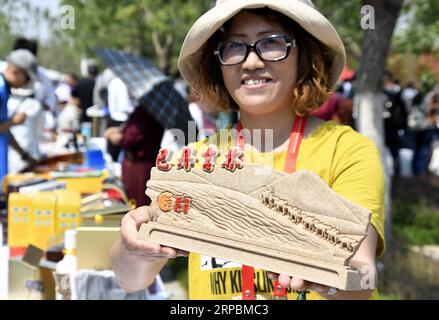 (190612) -- PEKING, 12. Juni 2019 (Xinhua) -- eine Handwerkerin präsentiert eine Skulptur während einer Veranstaltung zum Thema Alxa League und dessen Ejina Banner in der Autonomen Region Innere Mongolei in Nordchina während der Internationalen Gartenbauausstellung in Peking im Bezirk Yanqing, Peking, Hauptstadt von China, 12. Juni 2019. (Xinhua/Li Xin) CHINA-PEKING-GARTENBAU EXPO-THEME EVENT-ALXA LEAGUE-EJINA BANNER (CN) PUBLICATIONxNOTxINxCHN Stockfoto