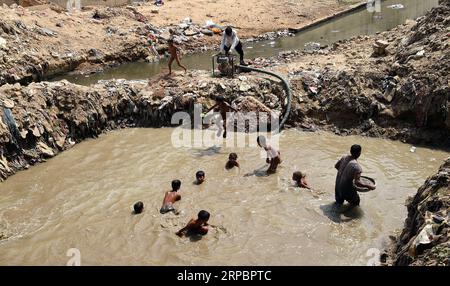 (190614) -- PEKING, 14. Juni 2019 (Xinhua) -- Jungen spielen in einem Teich in Neu-Delhi, Indien, 13. Juni 2019. In Neu-Delhi herrschen derzeit hohe Temperaturen, da sich die Hitzewelle im ganzen Land fortsetzt. (Xinhua/Zhang Naijie) XINHUA FOTOS DES TAGES PUBLICATIONxNOTxINxCHN Stockfoto