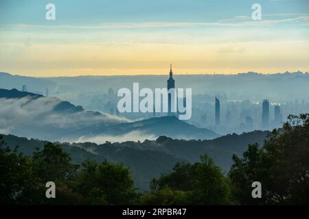 Twilight Transformation: Städtische Landschaft umgeben von Regenwolken. Blick auf die Stadtlandschaft vom Dajianshan Mountain, New Taipei City, Taiwan Stockfoto