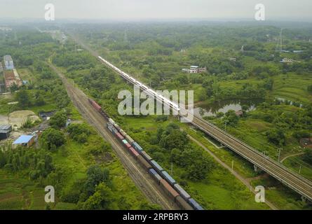 (190615) -- CHONGQING, 15. Juni 2019 (Xinhua) -- Luftaufnahme vom 12. Juni 2019 zeigt Frachtzüge (L), die am Bahnhof Fenggaopu entlang der Chengdu-Chongqing-Bahn halten, während ein Hochgeschwindigkeitszug auf der Chengdu-Chongqing-Hochgeschwindigkeitsbahn verkehrt. Die 505 km lange Bahnstrecke Chengdu-Chongqing verbindet Chengdu mit der südwestchinesischen Provinz Sichuan und der Gemeinde Chongqing und ist die erste Eisenbahnstrecke, die nach der Gründung der Volksrepublik China gebaut wurde. Es wurde von China entworfen und aus einheimischen Materialien gebaut. Der Bau der Eisenbahn begann im Juni 1950, und die W Stockfoto