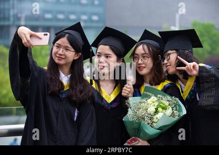 (190619) -- NANJING, 19. Juni 2019 (Xinhua) -- Absolventen nehmen Selfies nach der Eröffnungszeremonie 2019 der Nanjing Universität in Nanjing, Hauptstadt der ostchinesischen Provinz Jiangsu, 18. Juni 2019. Etwa 3.200 Studenten der Universität Nanjing erreichten den Bachelor-Abschluss bei der Zeremonie am Dienstag. (Xinhua/Su Yang) CHINA-NANJING UNIVERSITY-COMPLEMENT CEREMONY (CN) PUBLICATIONxNOTxINxCHN Stockfoto