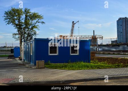 Elektrohaus mit Stromleitungen. Haus mit Klimaanlage für Stromabschirmungen mit Fenstern. Vor dem Hintergrund des Neubaus Stockfoto