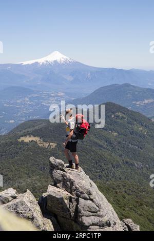 Wanderer macht Fotos auf dem Gipfel vor dem Vulkan Stockfoto