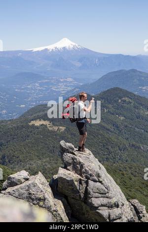 Wanderer macht Fotos auf dem Gipfel vor dem Vulkan Stockfoto
