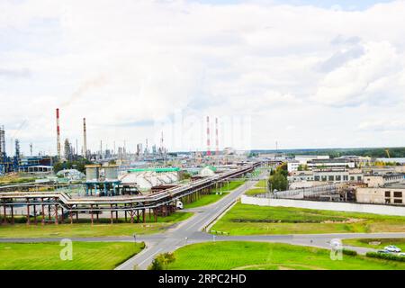 Industrielandschaft. Panoramablick auf die technologischen Rohre. Werkseinstellungen. Aus den chemischen rot-weißen Rohren kommt Rauch. Produktionsgebäude Stockfoto
