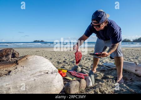 Man kocht Essen am Lagerfeuer am Strand, â€ Tofino, British Columbia, Kanada Stockfoto