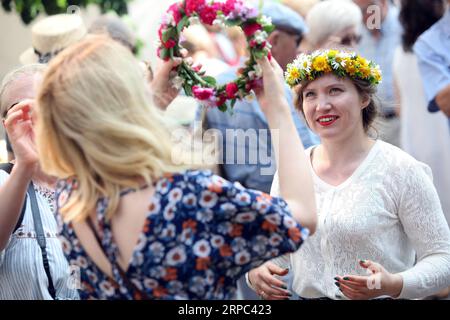 (190622) -- RIGA, 22. Juni 2019 -- Frauen, die Blumenkronen tragen, werden auf dem Midsummer Festival Ligo Market in Riga, Lettland, am 21. Juni 2019 gesehen. Am Freitag wurde hier das jährliche Mittsommerfest Ligo Market eröffnet, bei dem Bauern und Handwerker aus ganz Lettland Spezialitäten wie ländliches Brot, Käse, traditionellen Tee, Honig, handgemachte Kuchen und Kapillen verkaufen. ) LETTLAND-RIGA-MIDSUMMER FESTIVAL LIGO MARKET EDIJSXPALENS PUBLICATIONXNOTXINXCHN Stockfoto